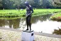 Voetenbadend meisje aan de waterkant van de Linschoten, op de achtergrond het bosje van Kromwijk